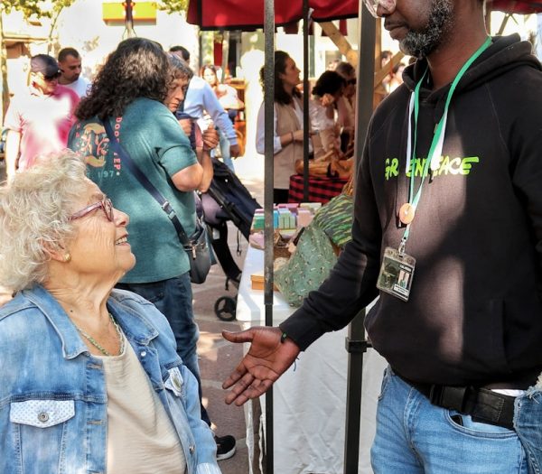 Man talking to woman at outdoor market